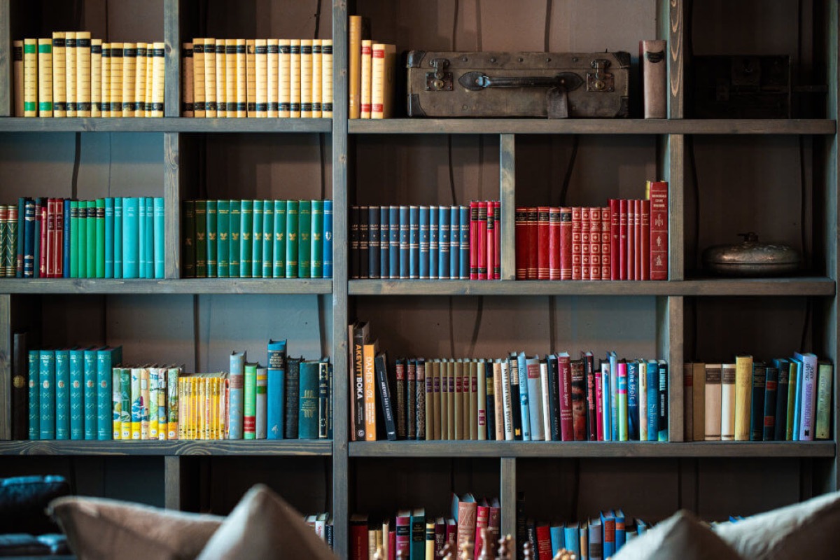 Bokhylle med fargesorterte bøker i fellesbiblioteket